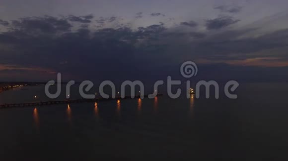夜间飞越海上码头和帆船视频的预览图