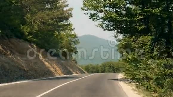 在山路上行驶穿过森林转弯在山岳灿烂的夏日在空路上驾车视频的预览图