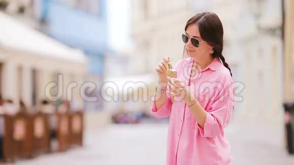 年轻的女模特在户外吃冰淇淋夏季概念在炎热的日子里用甜冰淇淋泡面视频的预览图