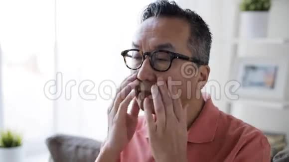 戴眼镜的疲惫男人在家里揉眼睛视频的预览图
