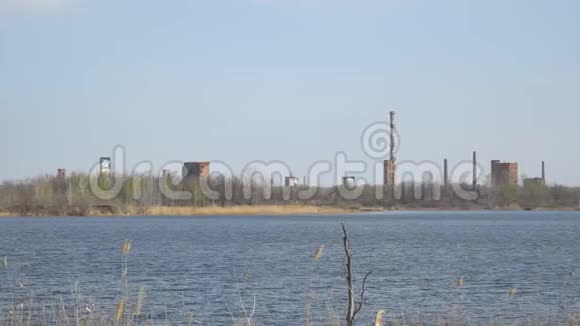 废弃的化工厂河岸上有烟囱视频的预览图