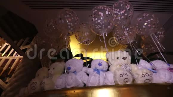 一排坐着的泰迪熊白色的泰迪熊氦气球脖子上戴着蝴蝶的可爱的泰迪熊柔软的玩具视频的预览图