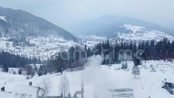 冬季山区有人居住地区的空中活动雪山山坡上的村庄建筑和房屋视频的预览图