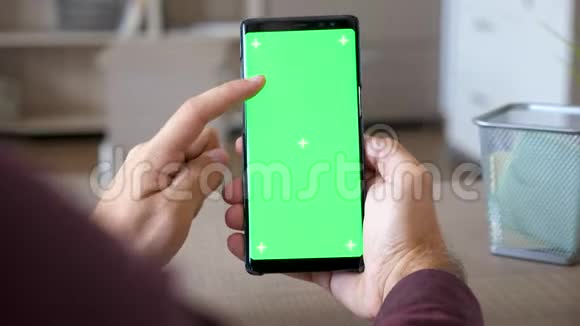 手里拿着智能手机手里拿着绿色屏幕的彩色模型视频的预览图
