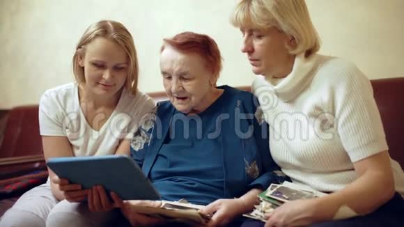 三个女人的家人在触摸板上看照片视频的预览图