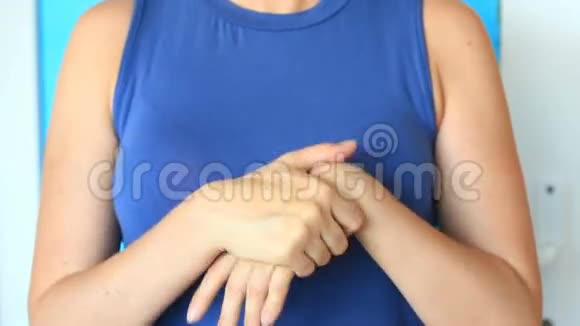 女人正在为柔软的护肤品而捏手一个女人用手霜在她的背景上涂抹她的手视频的预览图
