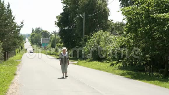 村里走在路上的一位老年妇女视频的预览图