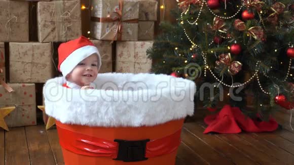 小圣诞老人坐在圣诞树旁一个大篮子里4K视频的预览图
