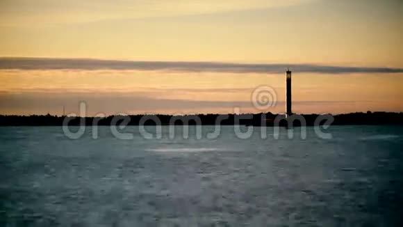 日出时的灯塔水面上的船影视频的预览图