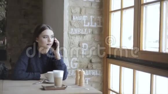 有智能手机的女人在咖啡厅喝咖啡视频的预览图