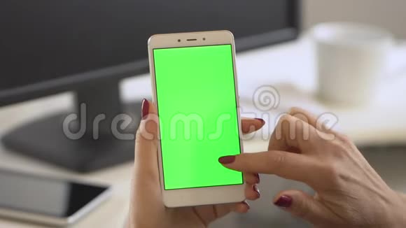 商务女性使用智能手机观看绿屏手机浏览色度键在线观看享受视频的预览图