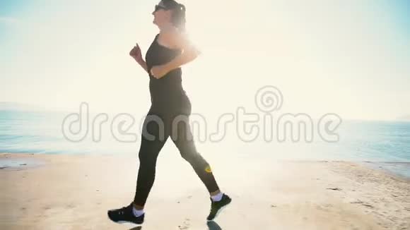 健康的年轻女子日出时在海边奔跑视频的预览图
