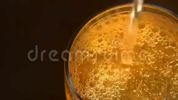 一杯带泡泡的啤酒在黑暗的背面视频的预览图