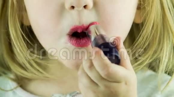 小可爱的女孩用红唇膏做嘴唇视频的预览图