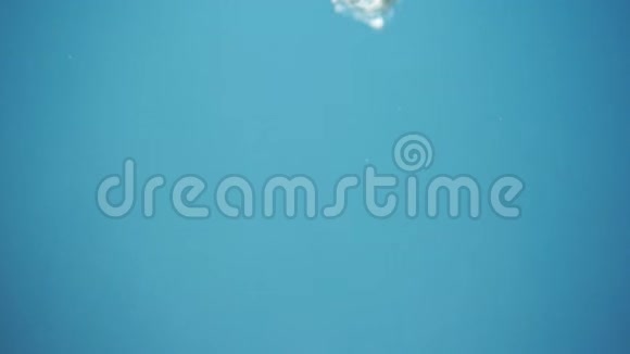 一颗新鲜的樱桃在蓝色的背景上溅入水中视频的预览图