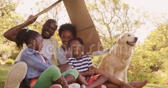 可爱的一家人和一只狗坐在公园里视频的预览图
