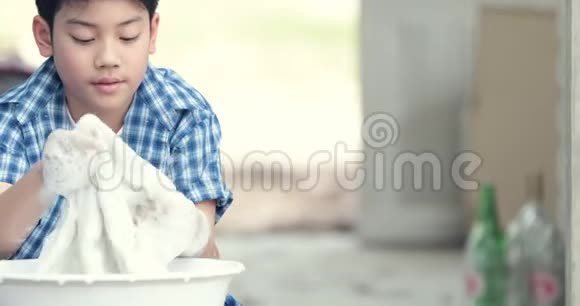 亚洲男孩用手洗毛巾泰国小男孩在家做家务视频的预览图