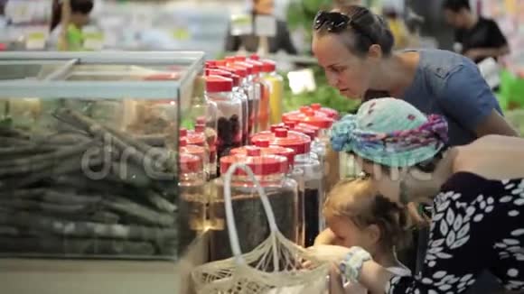 两位年轻的女士在超市的杂货店挑选香料视频的预览图