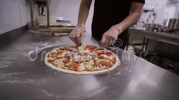厨师在商业厨房的披萨上添加橄榄视频的预览图