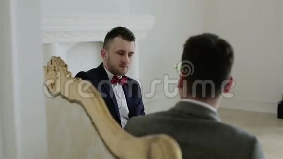 两个年轻英俊的商人讨论生意坐在一张老式沙发上视频的预览图