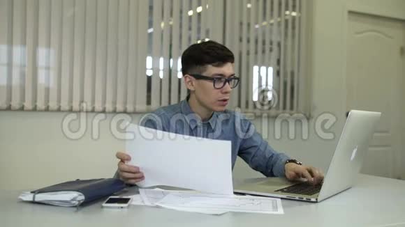 偶然的年轻人在办公室工作坐在办公桌前用键盘打字视频的预览图