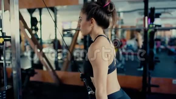 年轻漂亮的黑发女孩在健身房里留着长发在健身房4k视频上做运动视频的预览图