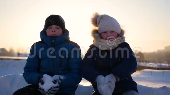 快乐的孩子们在雪地里玩耍在公园里撒雪视频的预览图