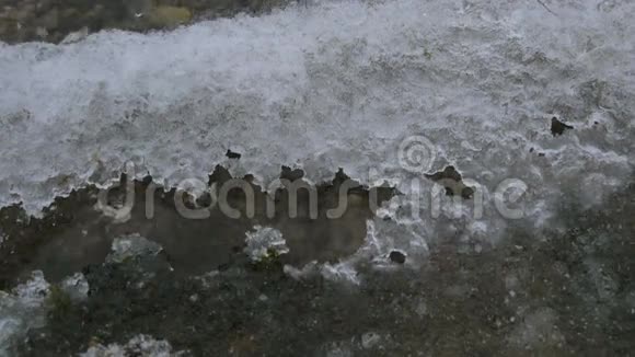 冬天一片美丽晶莹的清水在冰天雪地里拍打着岸边冬天的水通过融化的冰视频的预览图