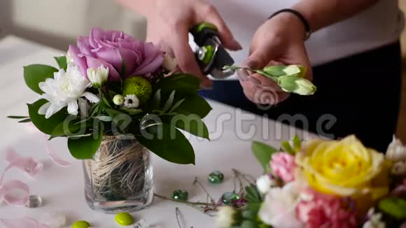 花商女孩在一个4k的小花瓶里收集一束漂亮的玫瑰和其他花视频的预览图