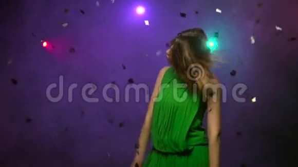 穿绿色连衣裙的年轻女子的特写舞蹈慢动作视频的预览图
