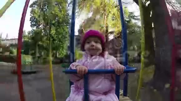 可爱的小女孩在秋日的秋千上玩得很开心视频的预览图
