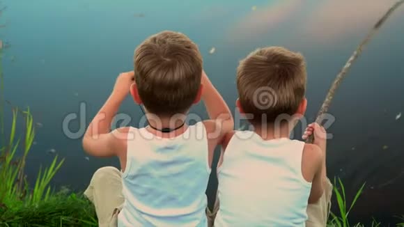 两兄弟在露天捕鱼两个小孩子在达查的一个池塘里钓鱼夏天美丽的湖视频的预览图