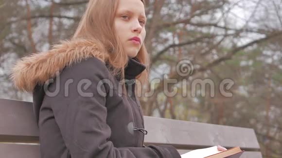 十几岁的女孩在公园里看书4UHDK视频的预览图