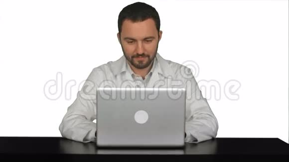 微笑男医生坐在桌上手提电脑视频的预览图