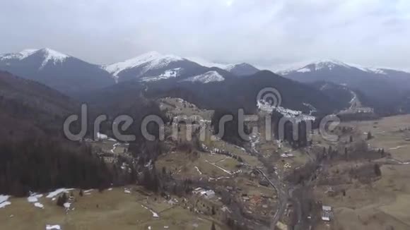 在覆盖着雪的多岩山脉附近飞行视频的预览图