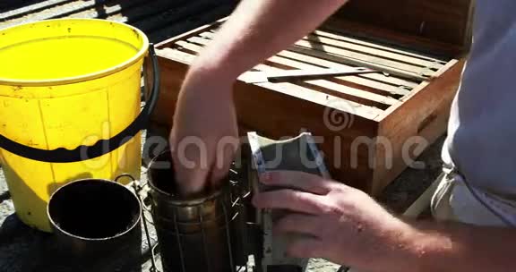 养蜂人准备吸烟者在养蜂场收割视频的预览图