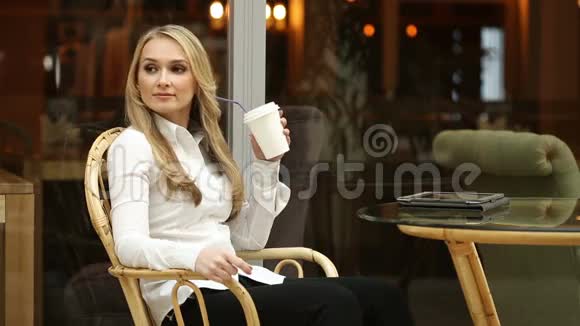 快乐的年轻女人在咖啡店里喝咖啡或茶使用平板电脑商务午餐的女商人视频的预览图