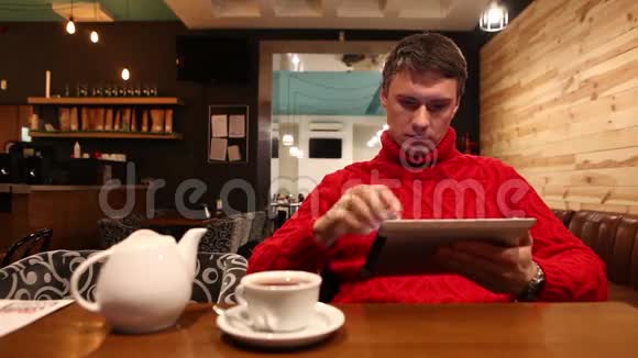 带着平板电脑的人在咖啡馆喝茶视频的预览图