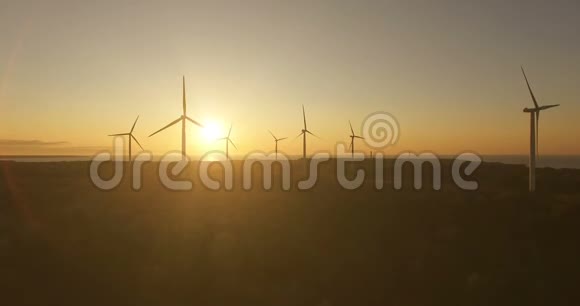 高空观风发电机在傍晚的天空上的田野风力发电机旋转叶片并提取电能视频的预览图