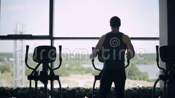 在健身房锻炼的帅哥剪影多利向左向右射击视频的预览图