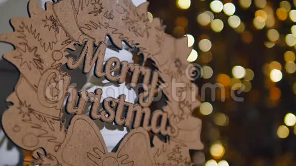 圣诞彩灯背景上印有圣诞快乐字样的木制标牌视频的预览图