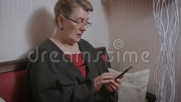 老年妇女在智能手机上打字视频的预览图