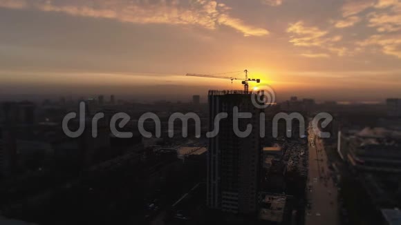 鸟瞰黄塔楼起重机从一个建筑公寓房地产的建筑工地飞来飞去视频的预览图