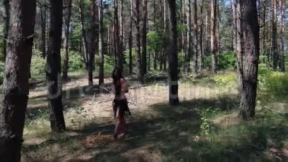 穿着古代皮衣的野蛮女人拿着剑在森林里行走视频的预览图