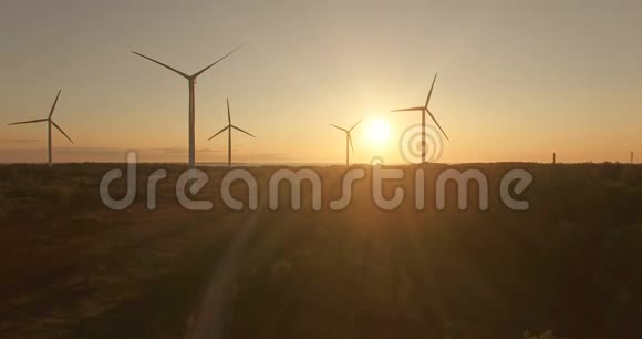 高空观风发电机在傍晚的天空上的田野视频的预览图