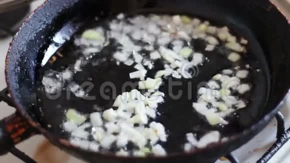 在平底锅中用油煎洋葱切碎视频的预览图