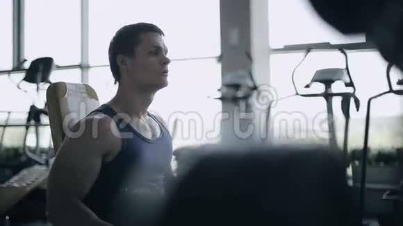 男子健美运动员在健身房用哑铃进行锻炼面部照片轮廓视频的预览图