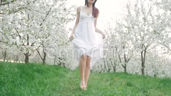 春天的时尚肖像一位美丽快乐的年轻女子穿着白色连衣裙棕色长发奔跑享受着快乐视频的预览图