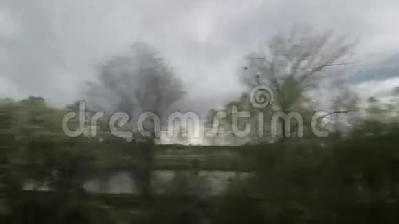 从坐火车的窗口看风景树木森林房子在阴天视频的预览图