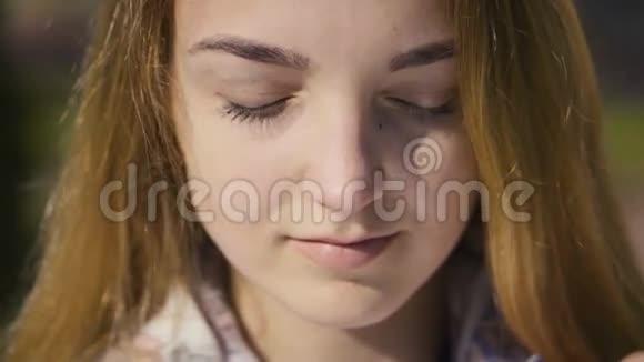 一位金发微笑少女的特写肖像视频的预览图